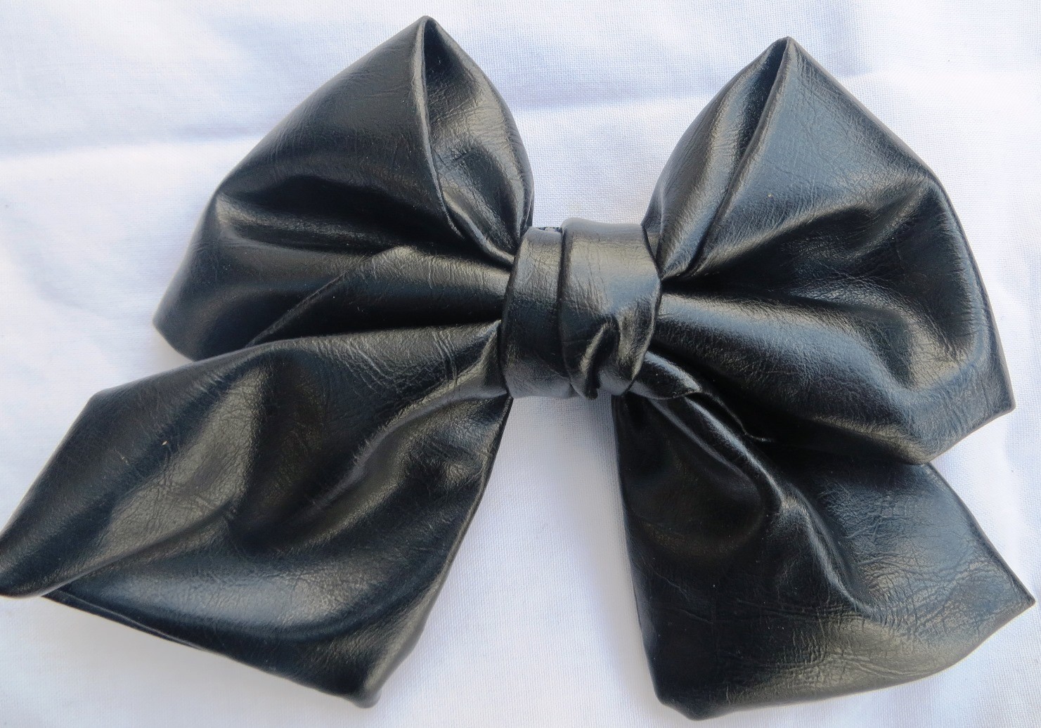 Black faux leather metallic look bow
