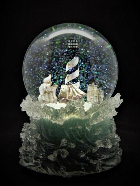 Bola de cristal con música. Faro en el mar