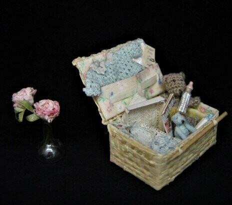 Cesta con accesorios de bebé en miniatura