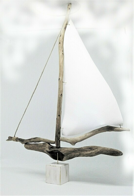Large driftwood boat with canvas sail.
