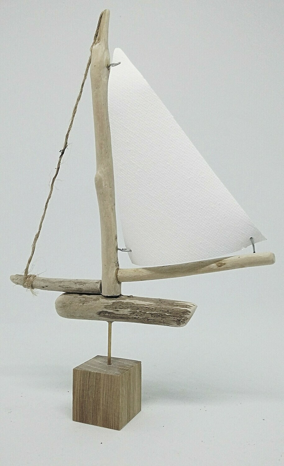 Small driftwood boat with canvas sail.