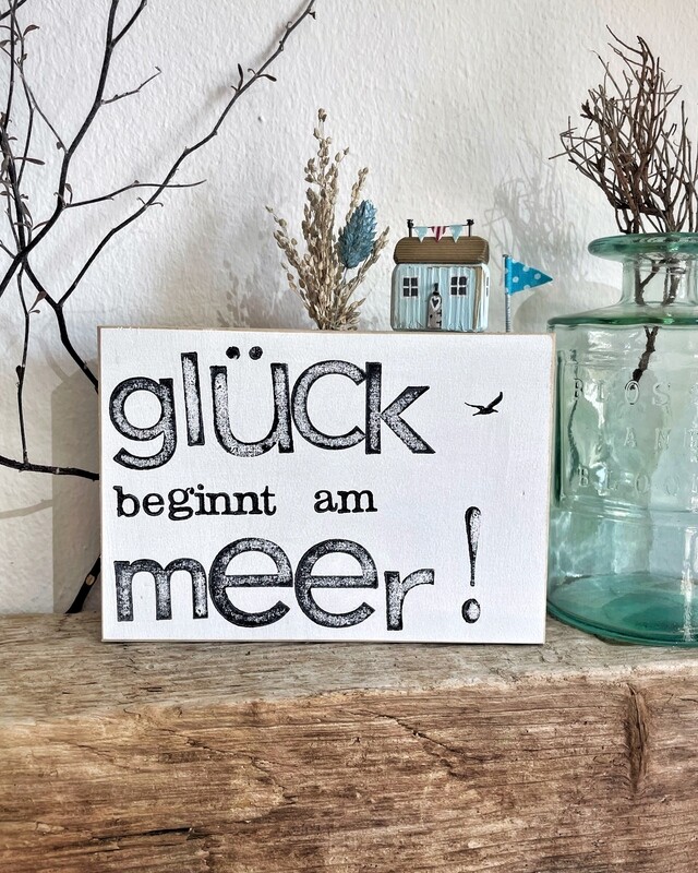 Schild „Glück beginnt am Meer“