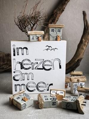 Schild mit Häuschen, z. B. im Herzen am Meer Schild mit Häuschen, z. B. im Herzen am Meer