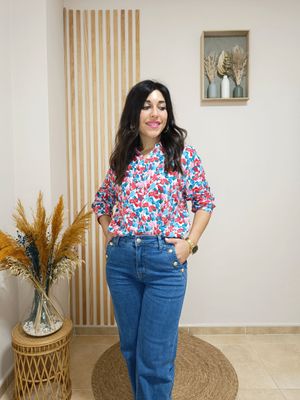 Camisa con estampado floral en tonos pasteles, destacando el rosa, azul y rojo sobre un fondo blanco