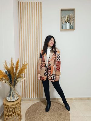 Chaqueta estilo blazer en antelina que combina el estampado animal print en tonos naranja con un diseño patchwork