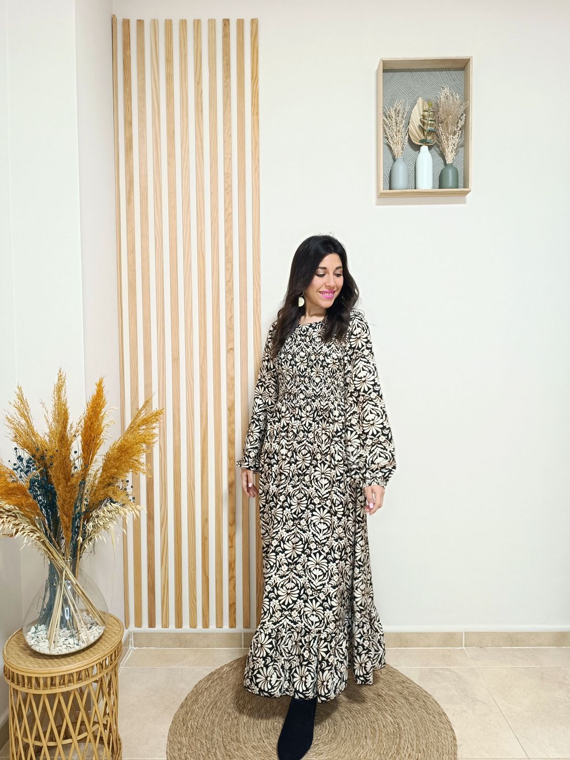 Vestido largo en color negro y con estampado floral en beige, con nido de abeja con goma elástica por la parte delantera del pecho y espalda, manga engomada para remangar al gusto.