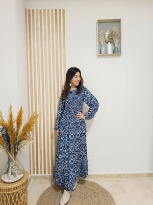 Vestido largo en color azul marino y con estampado floral en beige, con nido de abeja con goma elástica por la parte delantera del pecho y espalda, manga engomada para remangar al gusto.