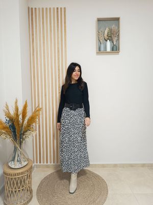 Falda plisada en estampado animal print en color negro con moteado blanco, con largo midi y cinturilla elástica