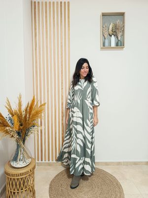 Vestido largo en nido de abeja con fondo en color verde kaki y un estampado blanco en forma de grandes hojas, con volante inferior y puño engomado
