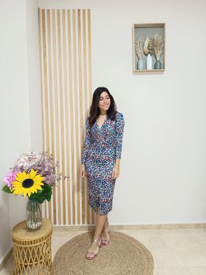 Vestido en licra fría con fondo color negro y motitas multicolor, escote en pico, largo midi con abertura central por la parte de delante, fruncido debajo del pecho para estilizar la silueta 
