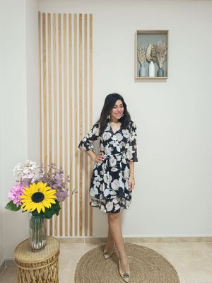 Vestido de gasa corto en tonos negros con estampado de hojas en beige, con escote de pico, cinturilla engomada y falda con volante