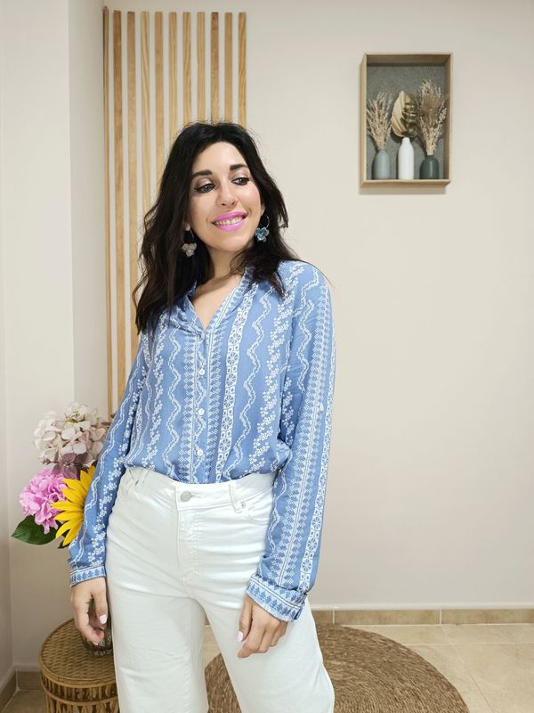 Camisa azul con cuello de pico y abotonada por la parte central, en fondo azul tejano con estampado geométrico en color blanco