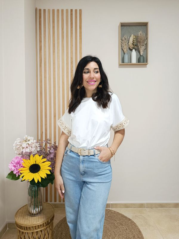 Camiseta básica en color blanco y manga corta con detalle en el filo de las mangas de una cenefa beige con motivo floral y glitter dorado