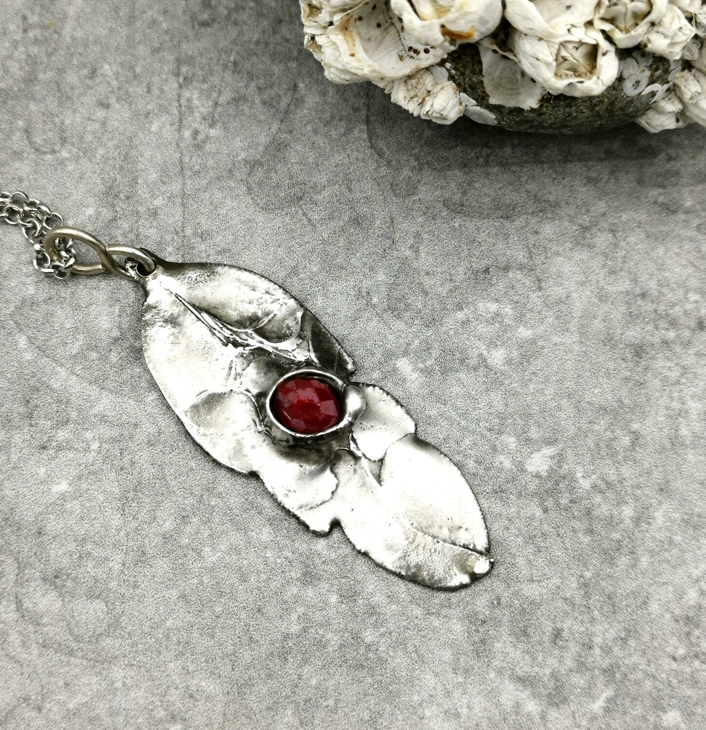 Feather Pendant with captured faceted ruby red bead