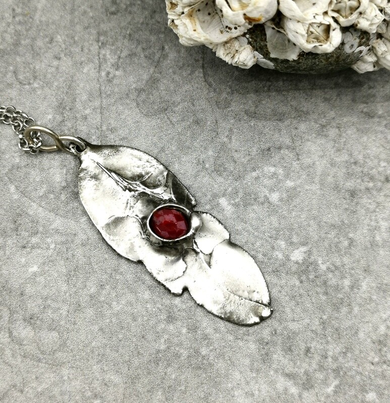 Feather Pendant with captured faceted ruby red bead