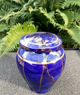 Ancient Creations pet cremation urn in royal blue with gold luster design, and real 22 karat gold banding.