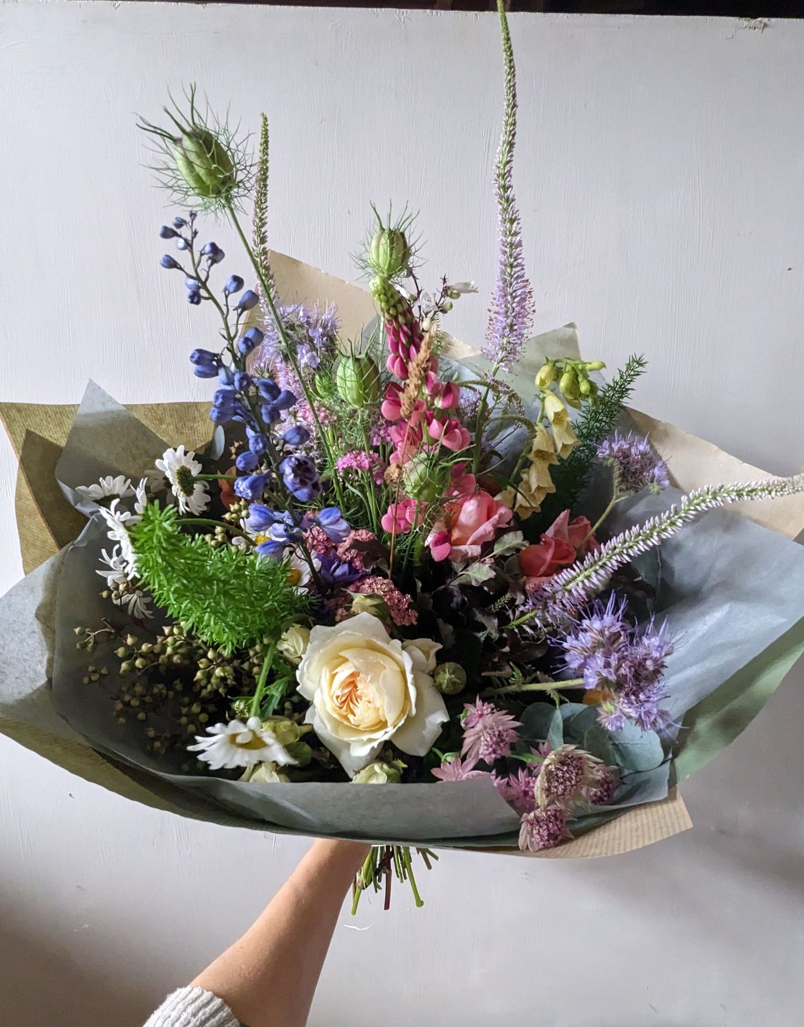 large fresh flower bouquet with delphiniums, roses and other summer flowers