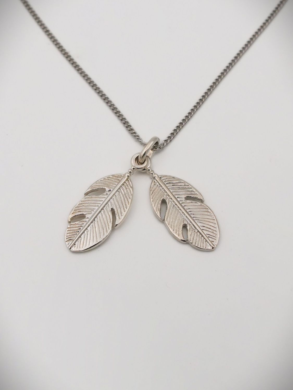 Moko Pounamu Sterling Silver Twin Feather Charm Necklace Moko Pounamu Sterling Silver Twin Feather Charm Necklace