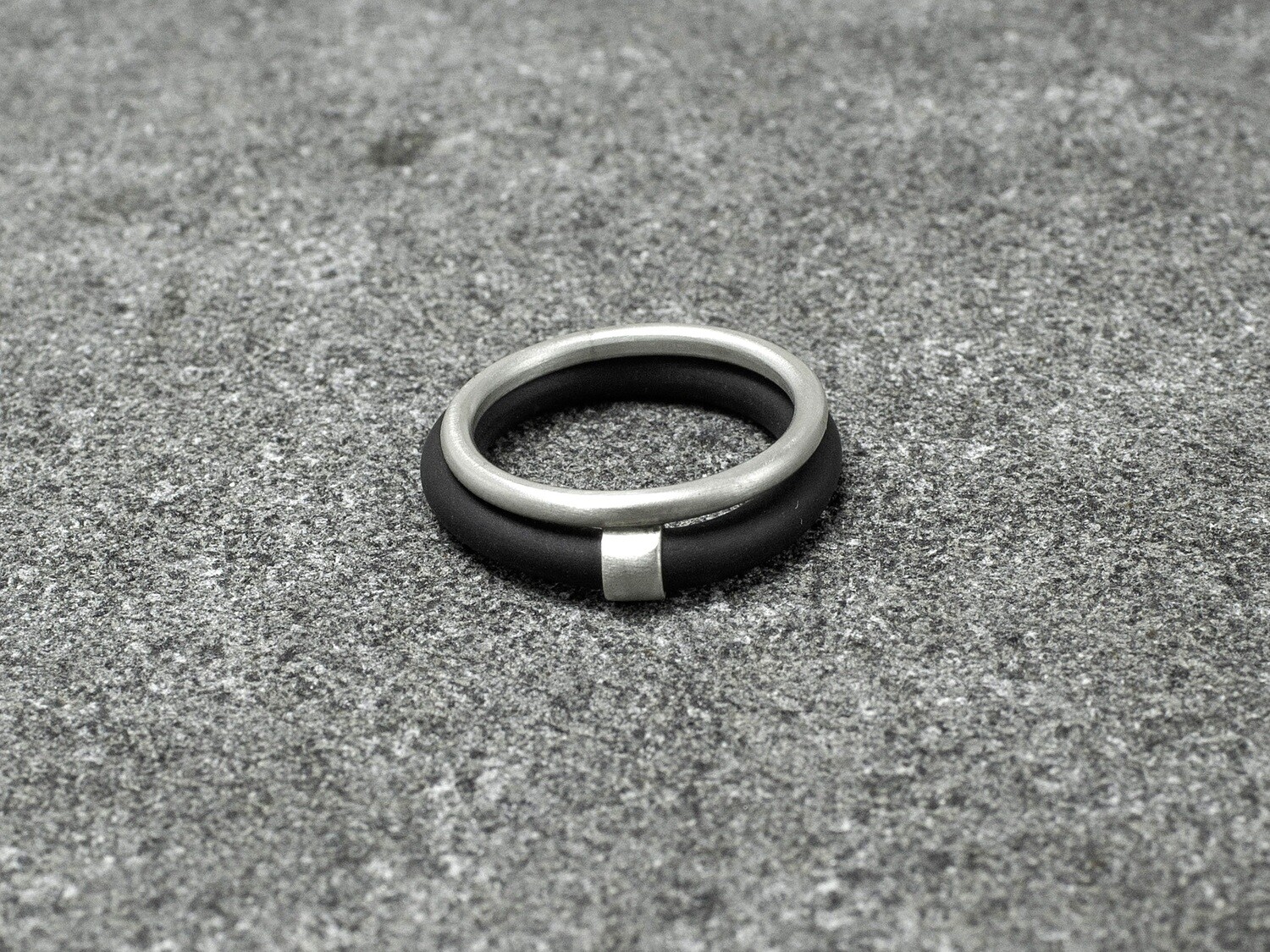 Geometric silver and caoutchouc ring.