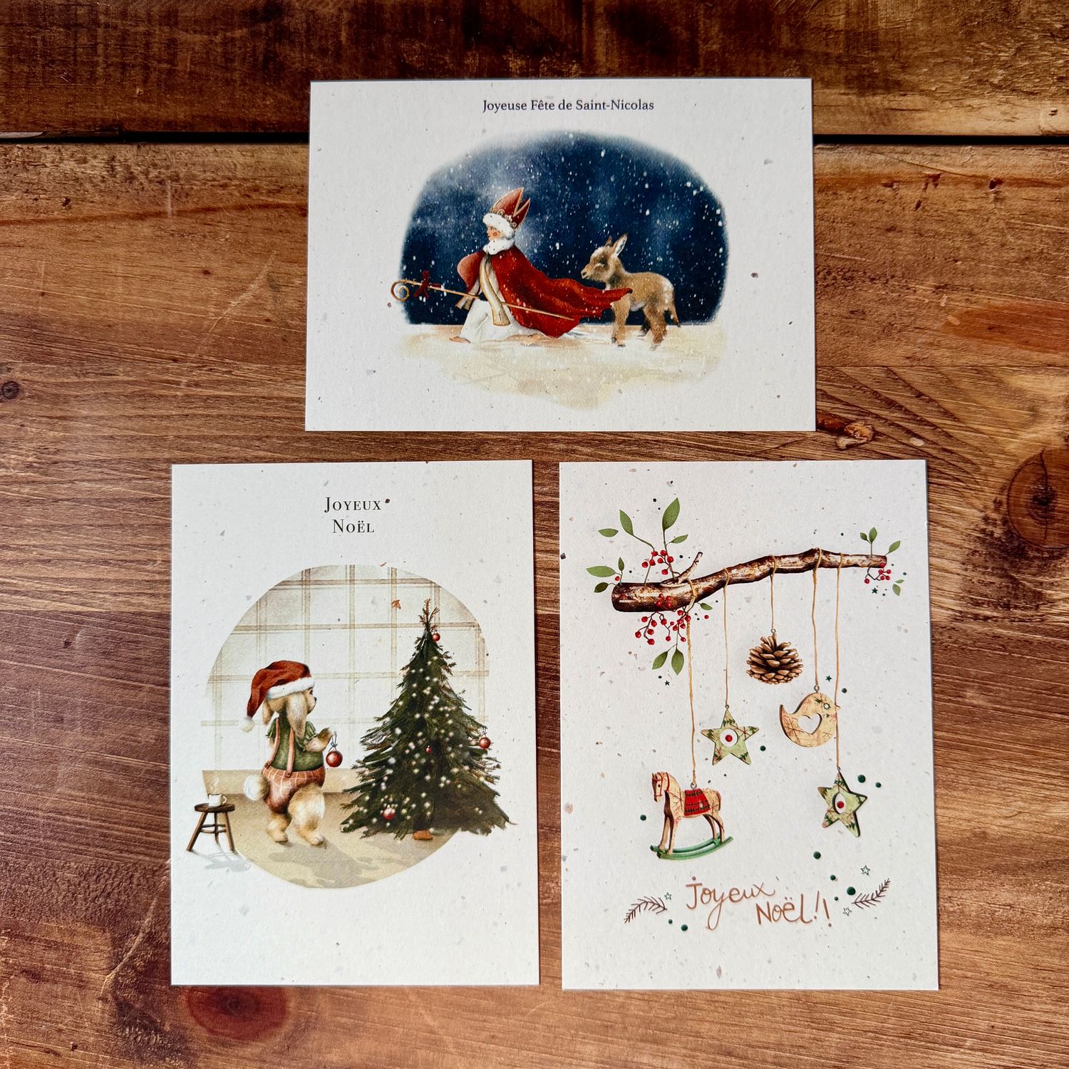 Trois cartes illustrées à l’aquarelle : Saint-Nicolas, lapin de Noël et décorations naturelles.
