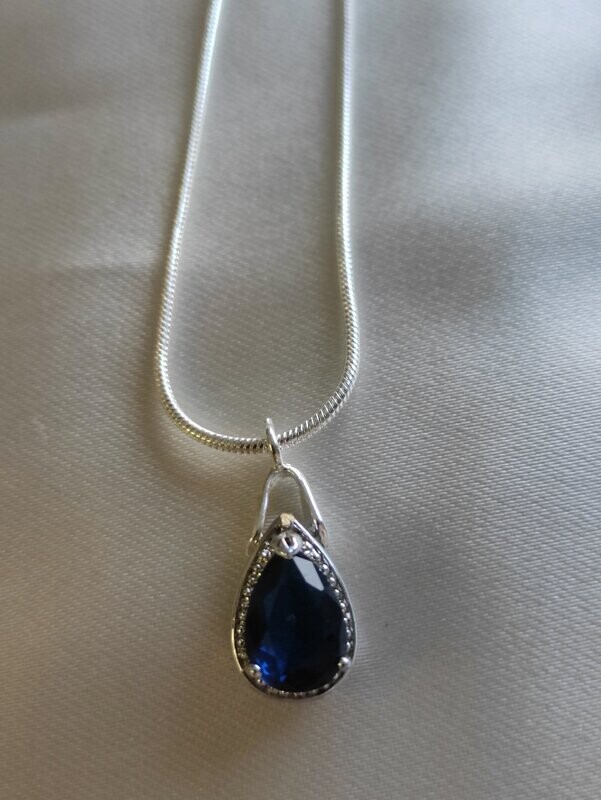 Colgante con topacio azul engastado en plata de ley.