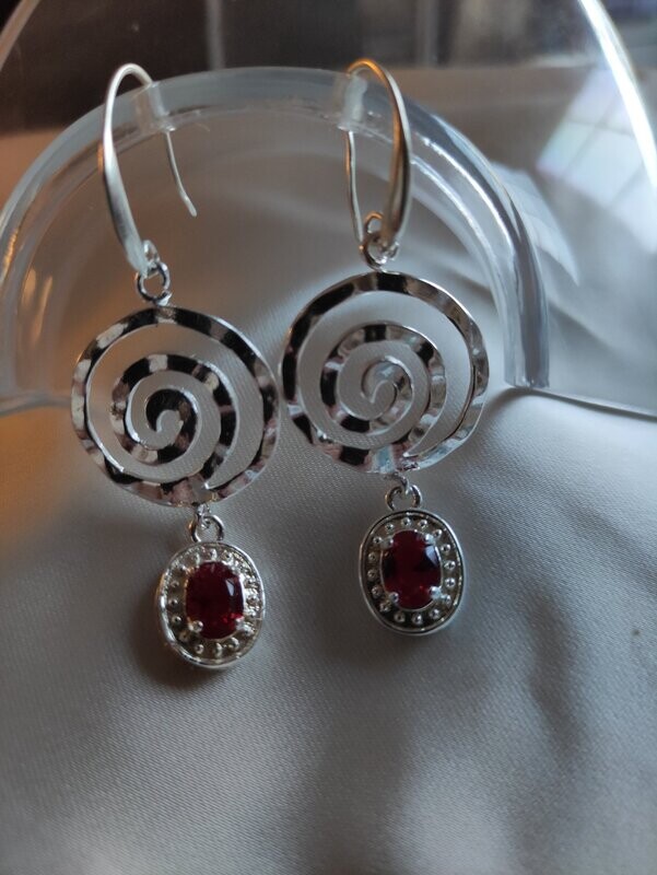 Pendientes con topacio rojo y elemento circular en plata.