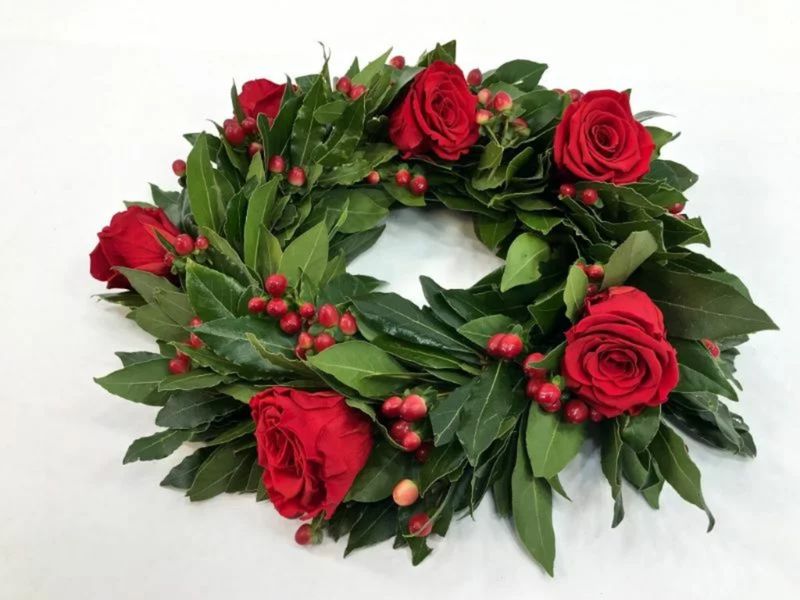 Corona di alloro con bacche e rose rosse