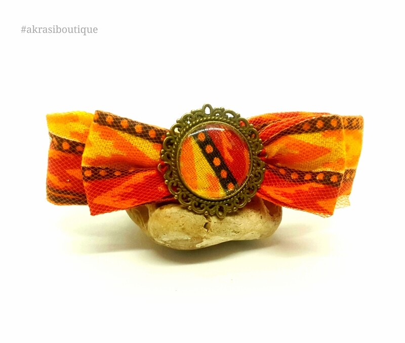 Dashiki bow barrette hair clip in orange netting with round bronze detail centre