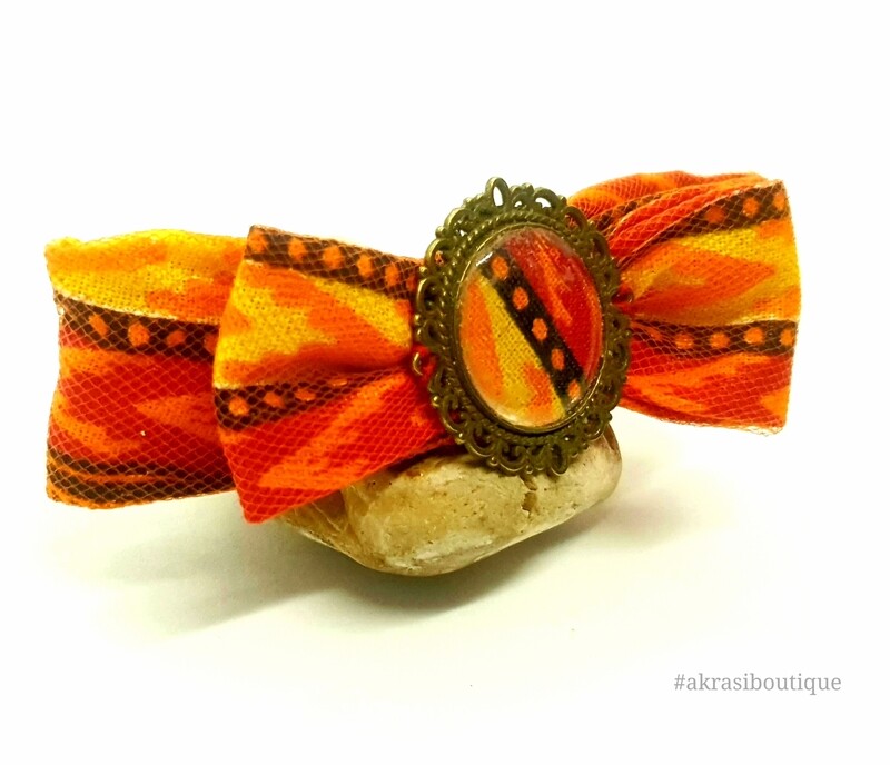 Dashiki bow barrette hair clip in orange netting with round bronze detail centre