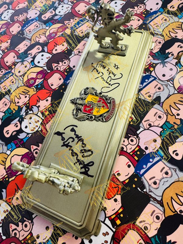 SOPORTE VARITA GRYFFINDOR FIRMADO POR PADMA PATIL (AFSHAN AZAD) & KATIE BELL (GEORGINA LEONIDAS)