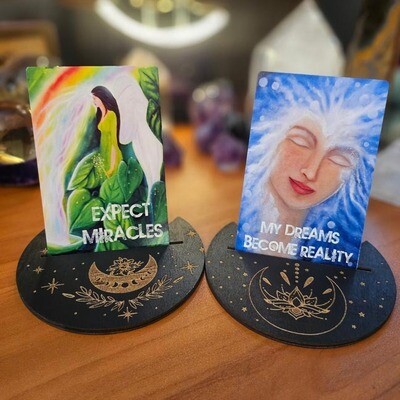 Meditation deck cards reading ‘Expect Miracles’ and ‘My Dreams Become Reality’ displayed on card holders.