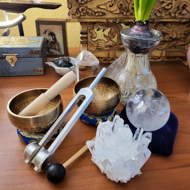 Tibetan Singing Bowls and Tuning forks with crystals on wooden surface
