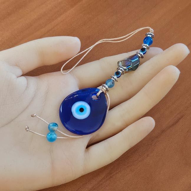 Handmade lampwork Eye of Light protection charm for aura safety, clarity, and spiritual shielding.