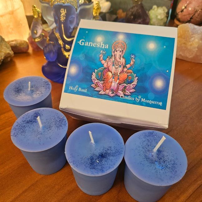 Four blue glittered votive candles beside a box labeled Ganesha – Holy Basil – Candles by Montserrat” 