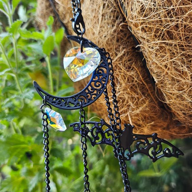 Bat suncatcher with glitter hearts and star prisms that cast rainbow light and nocturnal whimsy.