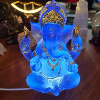 Translucent blue Ganesh statue with gold accents glowing from an LED lamp base