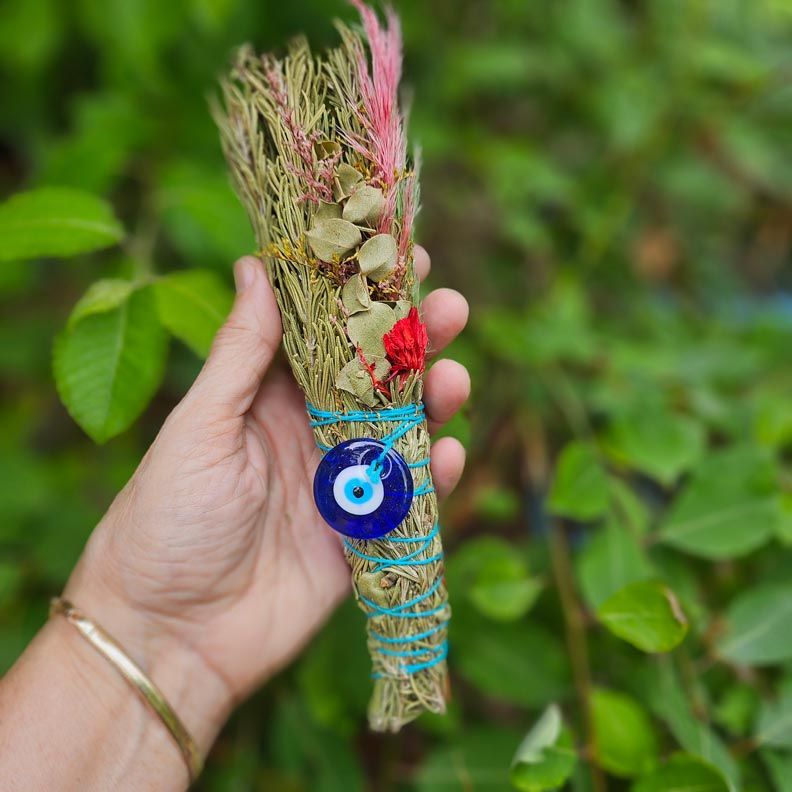 Guardian Bloom smudge bundle with rosemary, eucalyptus, wildflowers, and evil eye charm.
