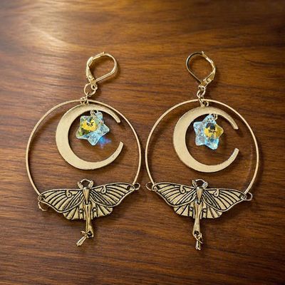 Luna Moth earrings with brass wings, crescent moons, and iridescent angel aura star crystals.