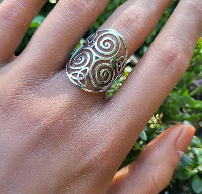 Adjustable stainless steel ring engraved with the Celtic Triskele triple‑spiral symbol.