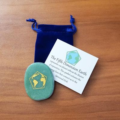 Green aventurine palm stone with gold earth design shown with a blue velvet pouch and a printed information card