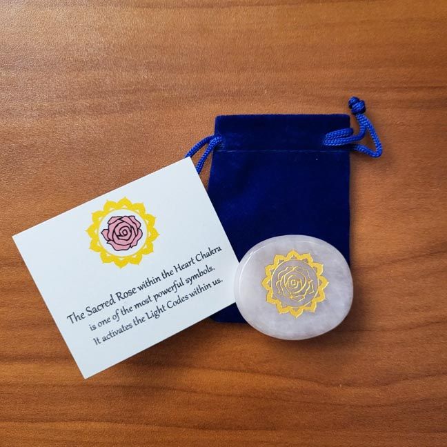 Rose quartz palm stone with gold mandala design shown with a blue velvet pouch and a printed information card