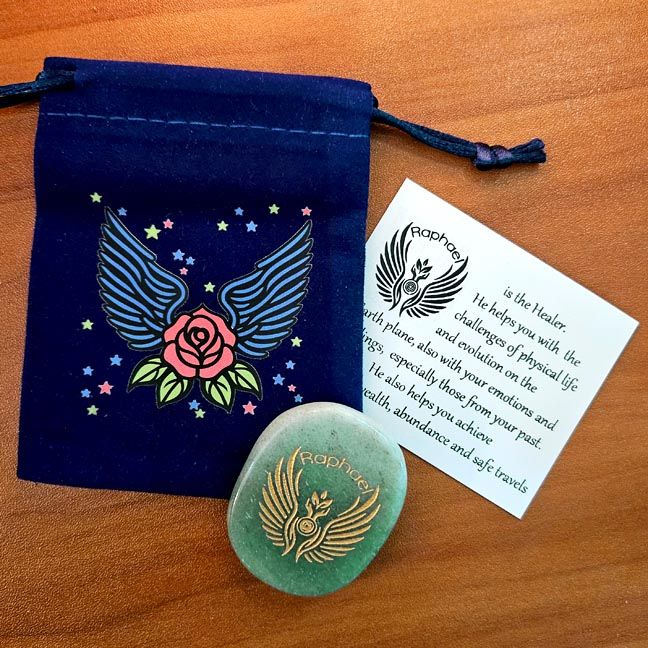 Green Aventurine Raphael stone beside a blue winged pouch with a rose design and a printed card behind it