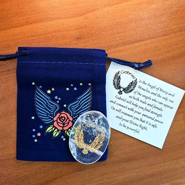 Clear Quartz Raphael stone beside a blue winged pouch with a rose design and a printed card behind it