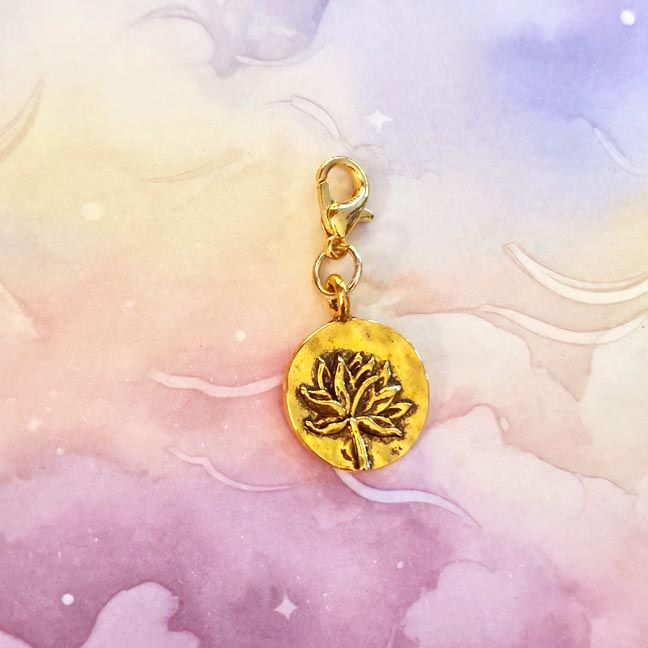 Golden lotus purse charm with warm glow and inspiring quote card.