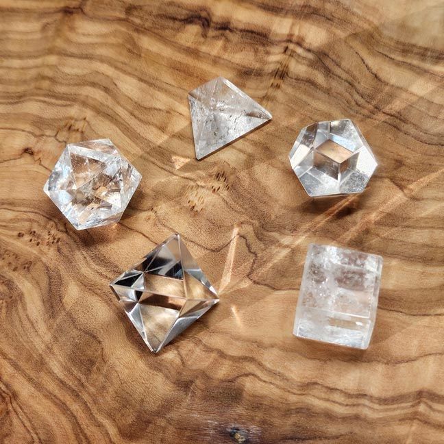 Clear Quartz 5‑piece Platonic Solids set for amplification, clarity, chakra alignment, and sacred geometry work.
