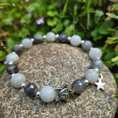 Labradorite bracelet with star charms on a natural stone and green plants in the background