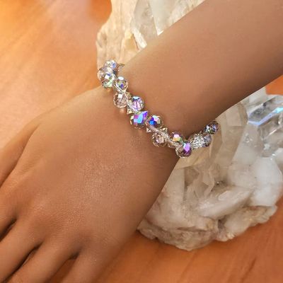 A faceted Austrian Crystal beads bracelet shimmering with purple, lavender, gold, and pink light.