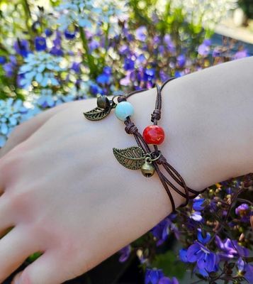Adjustable forest bracelet with ceramic seed bead and bronze leaf charm.