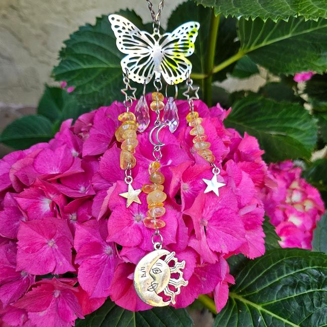 Silver butterfly suncatcher with citrine chips, rainbow prisms, and celestial charms on a flower