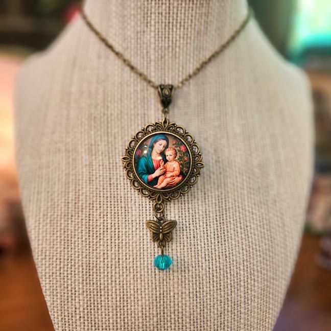Bronze Madonna and Child pendant with butterfly charm and aqua bead.